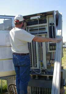 Photo of George Heufelder inspecting the pump control panel.