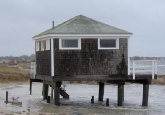 Erosion around a raised beach cottage on Surf Drive, Falmouth, MA.