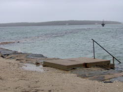 Spring high tide and storm surge covers the jetty at Megansett Beach.